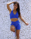 Shorts made out of royal blue textured print. Nylon spandex waist band for comfortable wear. Shop womens activewear online. Bodybuilder woman wearing blue gym set.